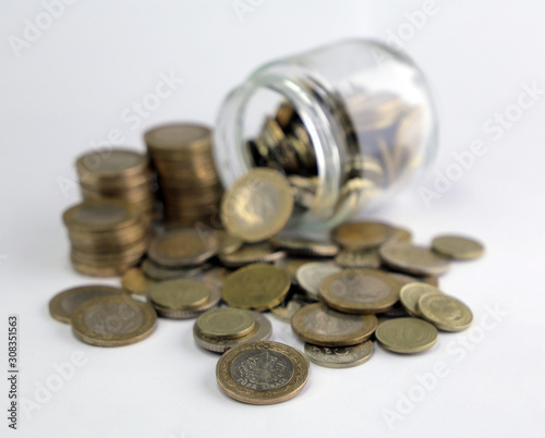 Rising coins, magnifying glass, Pile of mixed iron money coins background
