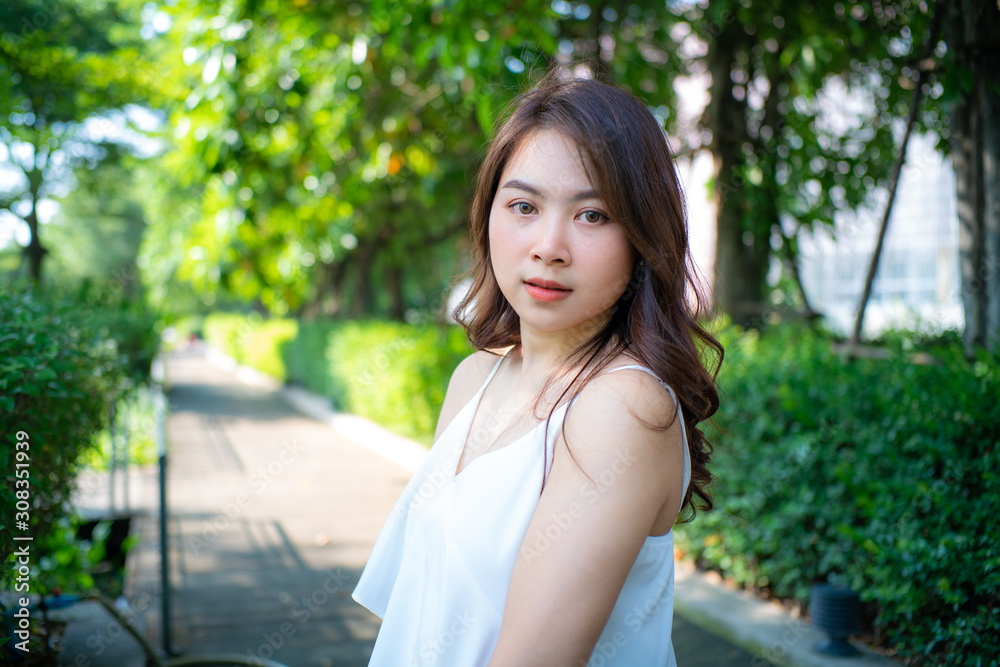 Beautiful wellness asian women walking in city park with white dress Beautiful wellness asian women walking in city park with white dress