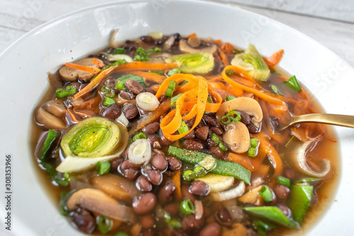 Фотография hearty vegetable soup with carrots, leeks, and black beans in beef broth