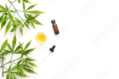 Valokuva Glass bottles with CBD oil, THC tincture and hemp leaves on a white background