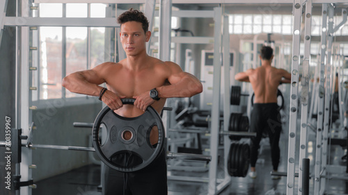 caucasian strong man doing exercise with weight lifting in gym club