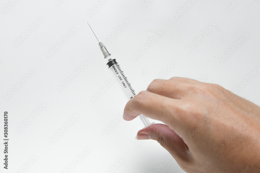 Hand holding the syringe on white background Hand holding the syringe on white background