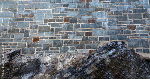 Part of a stone wall, with elements of natural rock for background or texture. photo