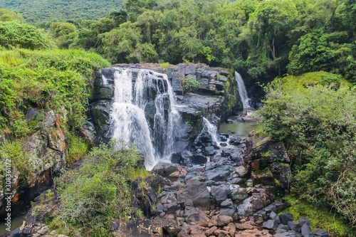 Beautiful waterfall with red flowers in Po  os de Caldas - Minas Gerais - Brazil