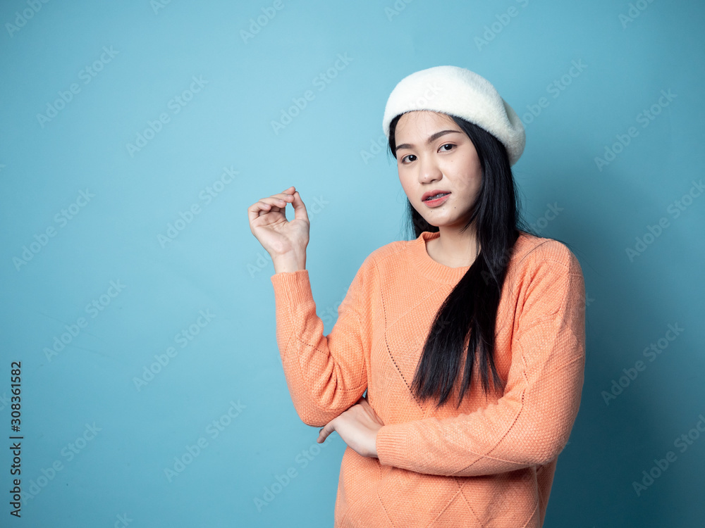 Asian woman wearing orange sweater on blue background, lifestyle concept. Asian woman wearing orange sweater on blue background, lifestyle concept.