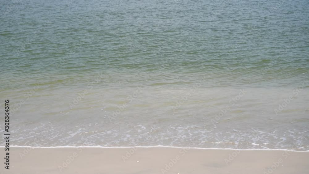 The sea with waves hit the sandy beach in the morning The sea with waves hit the sandy beach in the morning