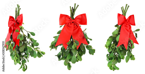 Canvas Print Three bunches of fresh green mistletoe tied with bright red Christmas bows