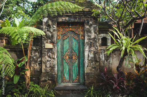 Traditional balinese handmade carved wooden door. Bali style furniture with ornament details. Old and vintage local style of architecture in Bali. Handmade details. photo