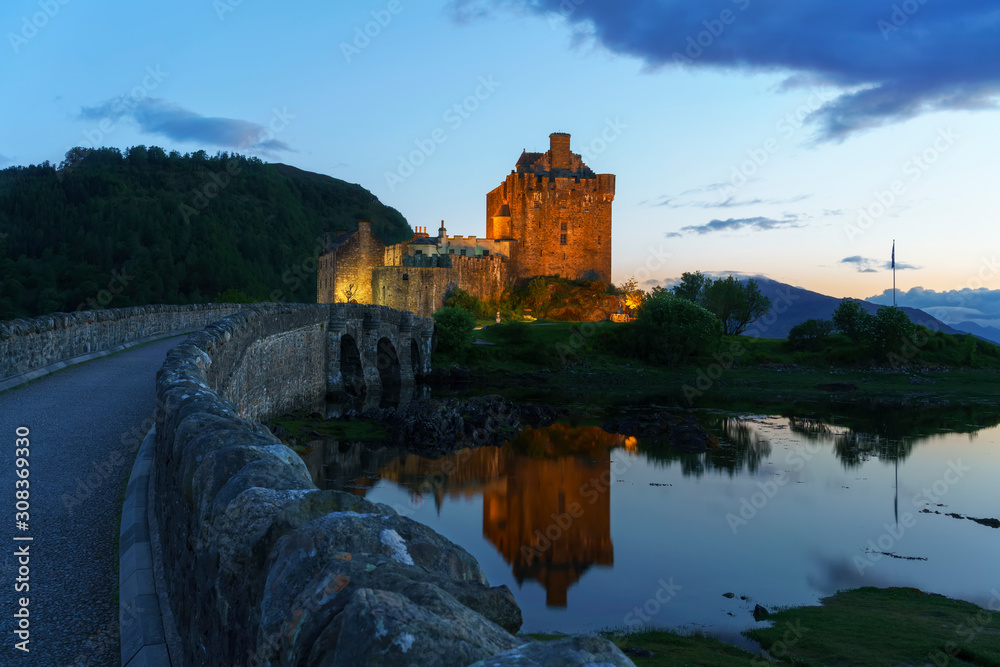 Eilean Donan Castle is one of the most important attractions in the Scottish highlands , at the point where three great sea-lochs meet in twilight with reflection,  Kyle of Lochalsh , Scotland