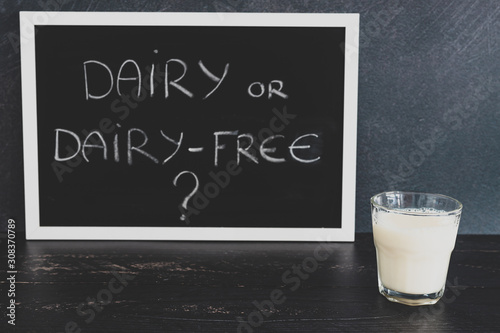 dairy or dairy-free debate  text on blackboard with glass of milk from topdown perspective