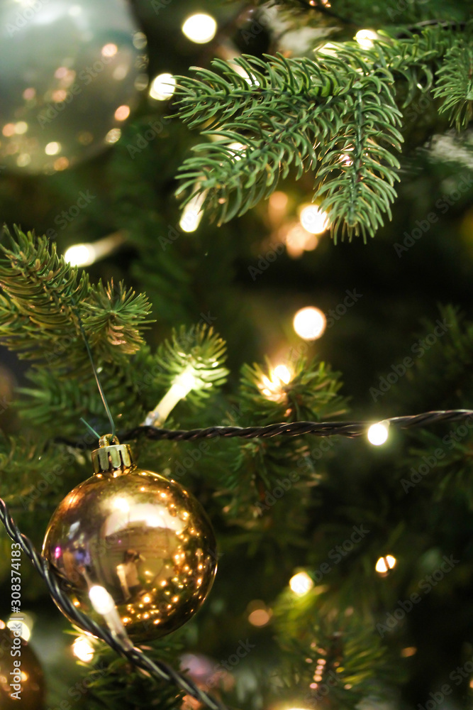 Christmas tree decorated with golden shiny baubles. Artificial fir tree