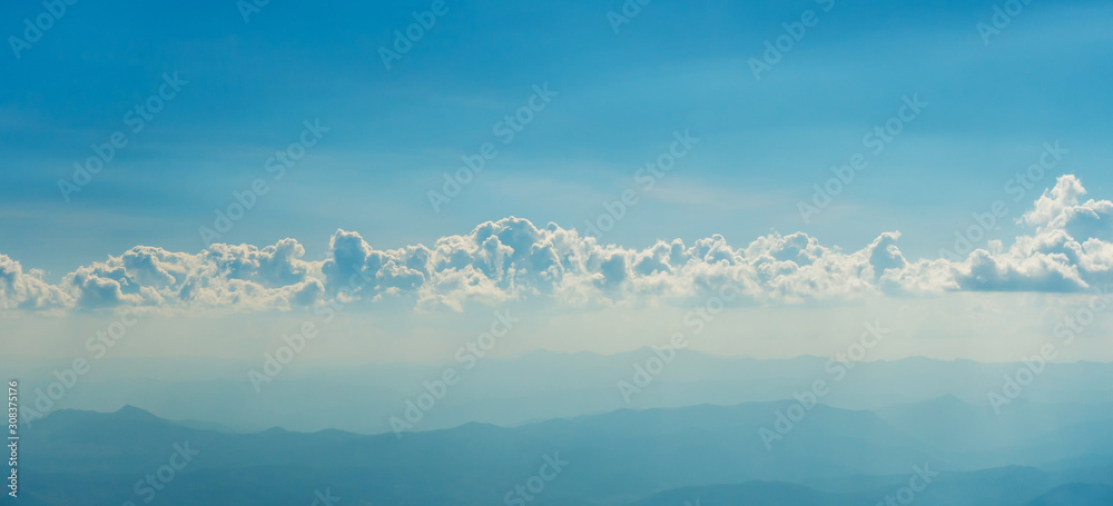 The blue sky and white clouds in the sunny day with fog on the mountain called Doi Inthanon in Thailand. 