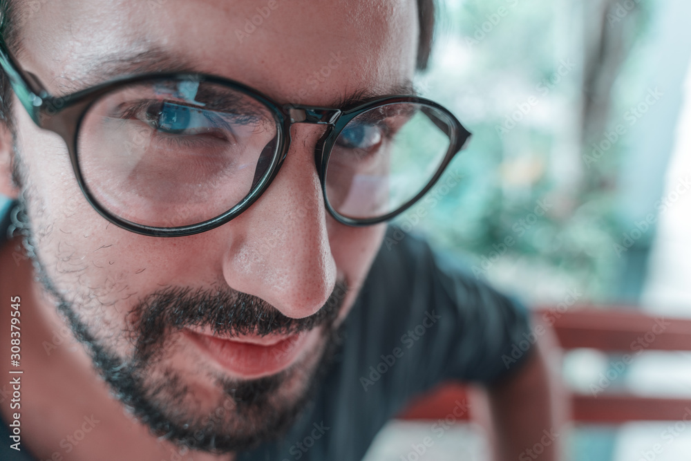 Handsome happy funny young curly latin man with a beard wearing glasses. Close-up face, wide angle shot Handsome happy funny young curly latin man with a beard wearing glasses. Close-up face, wide angle shot