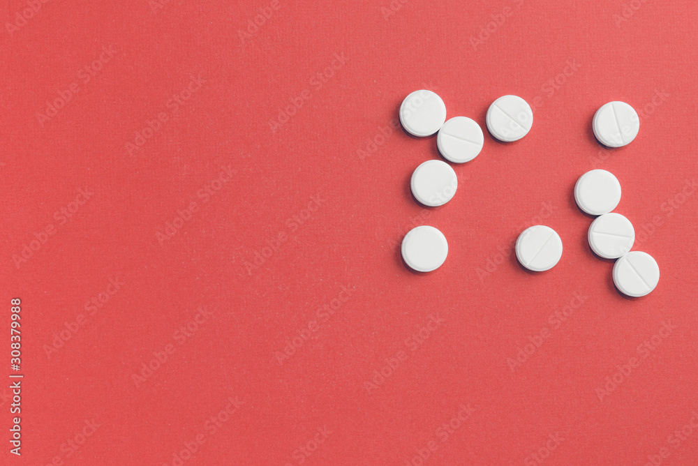 Round pills scattered on a red background. Top view, copy space. Pharmacy concept Round pills scattered on a red background. Top view, copy space. Pharmacy concept