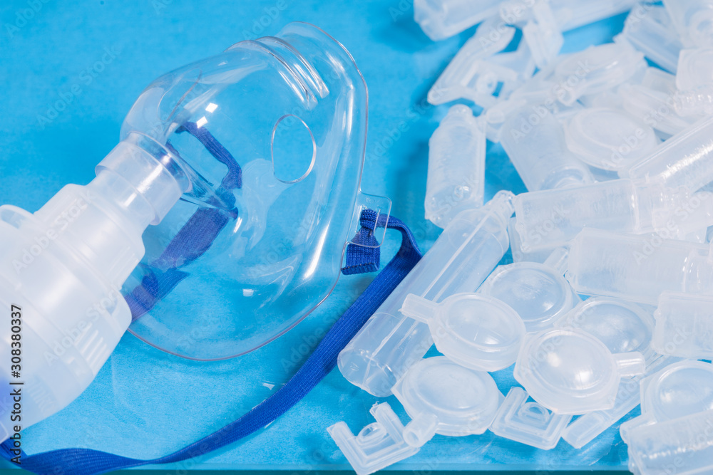 Mask for inhalation with opened empty bufuses or plastic ampoules various form and volume, selective focus. Concept image of pulmonary disease treatment.