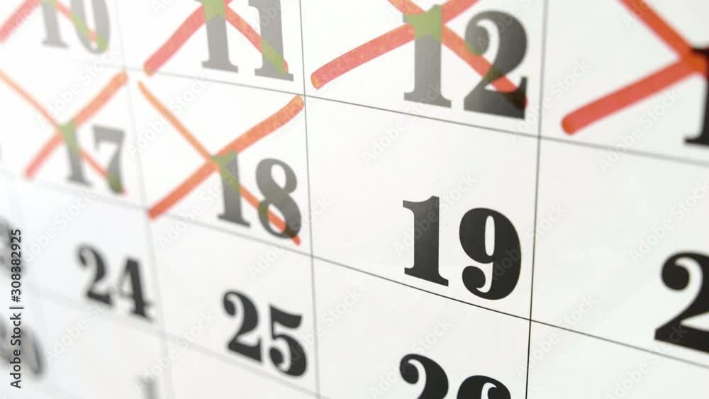 Female hand crosses with red marker the calendar day 19. Slow motion shot. Close up Female hand crosses with red marker the calendar day 19. Slow motion shot. Close up
