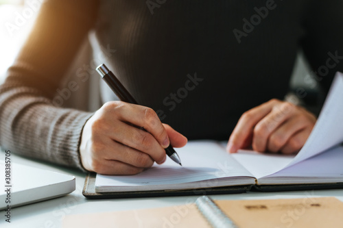 businessman hand working with new modern computer and writing on the notepad strategy diagram as concept morning light