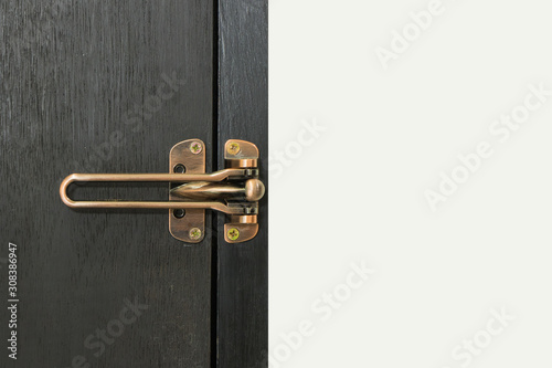 Safety latch guard on hotel room door, on black door and white wall,  Locked doors in hotel.