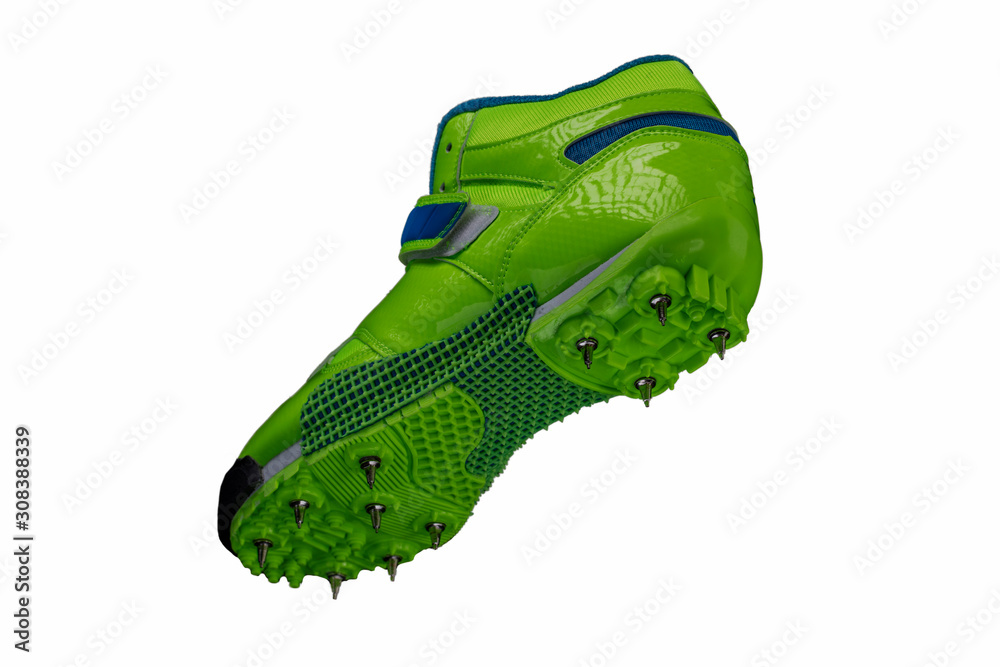 Green glossy sneaker with spikes on a white background. Sport shoes.