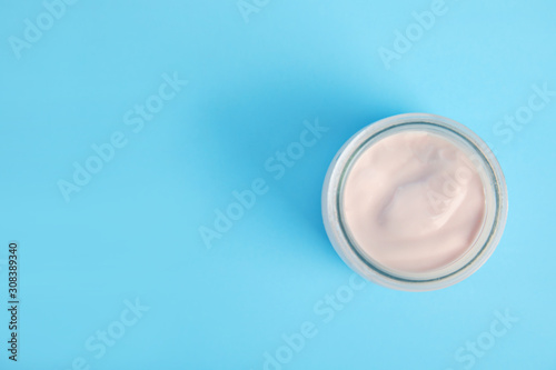 Tasty organic yogurt on light blue background, top view. Space for text