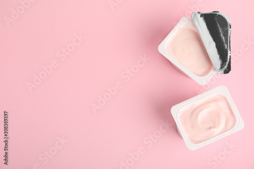 Tasty organic yogurt on pink background, flat lay. Space for text