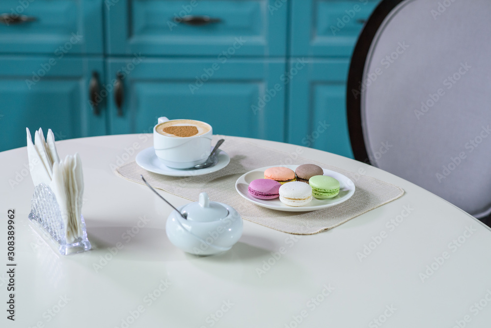 Delicious cappuccino and macaroons prepared on a table for a guest Delicious cappuccino and macaroons prepared on a table for a guest