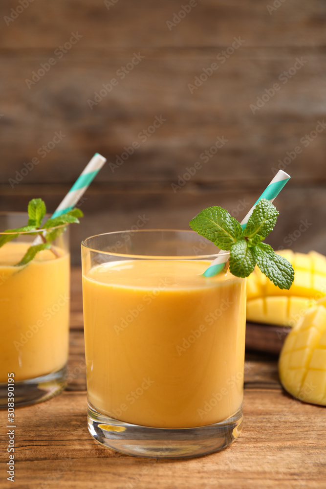 Fototapeta premium Fresh delicious mango drink on wooden table