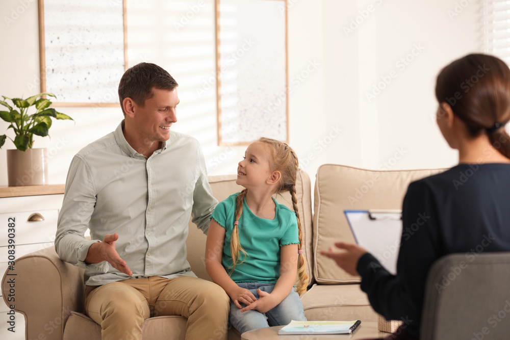 Little girl and her father on appointment with child psychotherapist indoors Little girl and her father on appointment with child psychotherapist indoors