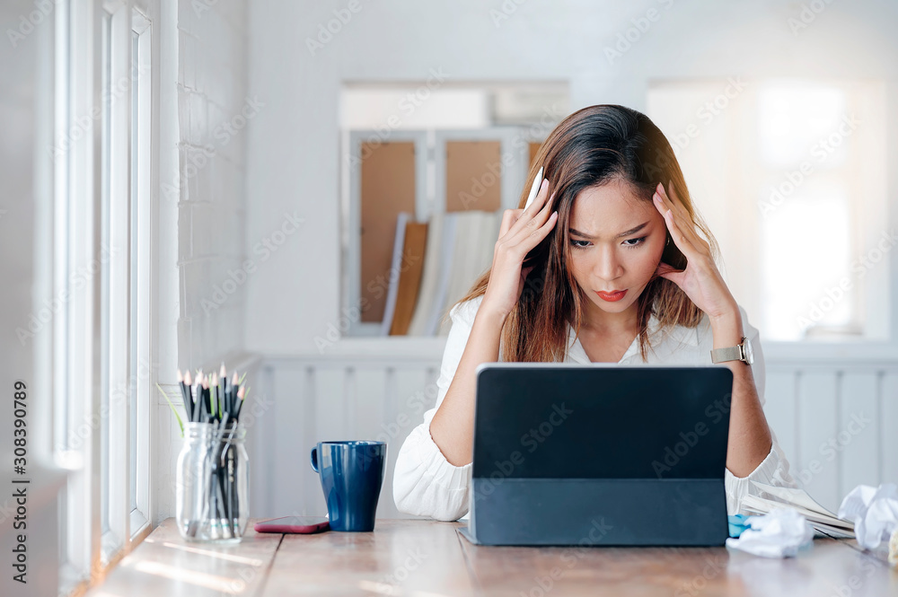 Tired businesswoman with headache working with laptop while sitting at office. Tired businesswoman with headache working with laptop while sitting at office.