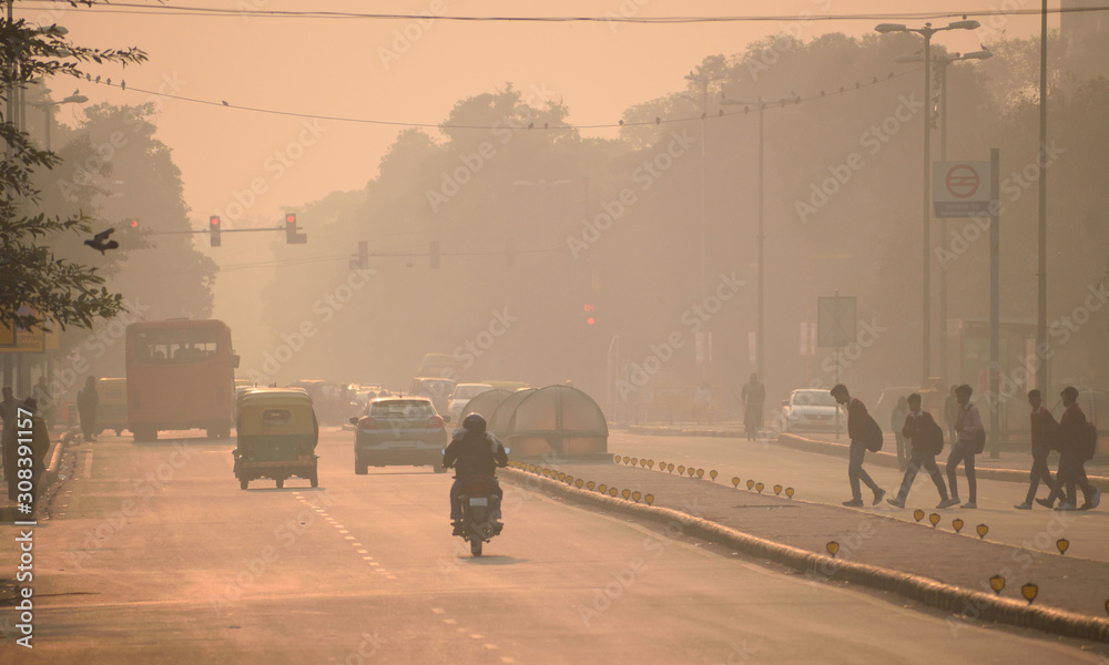 Plakat Ludzie spacerujący ulicami Delhi pośród smogu