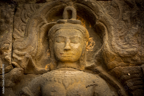 praying buddah in aisa, close up of a sculpture with the hand and smiling face 