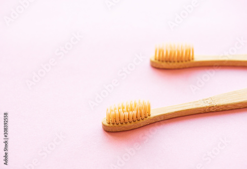 Bamboo toothbrushes on light pink background