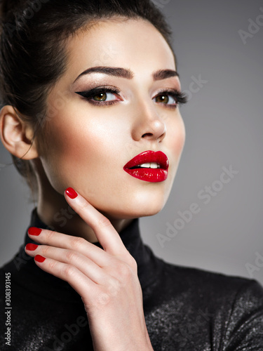 Beautiful woman with bright make-up and red nails.