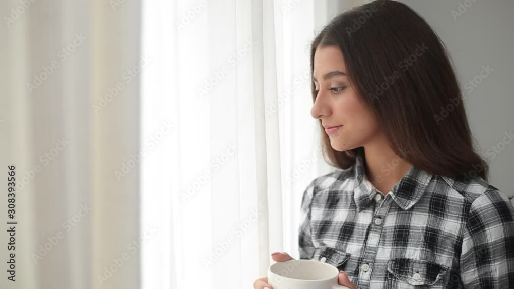Beautiful young woman waking up rejoices on a new morning holding a cup of hot coffee. Beautiful young woman waking up rejoices on a new morning holding a cup of hot coffee.