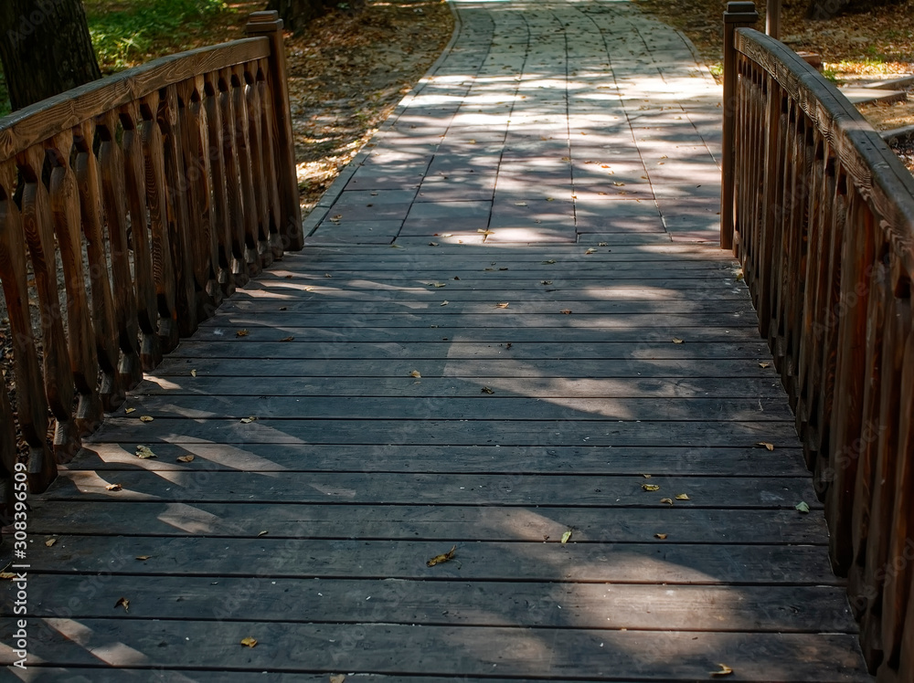 Fototapeta premium shadows from trees on a wooden bridge, Moscow.