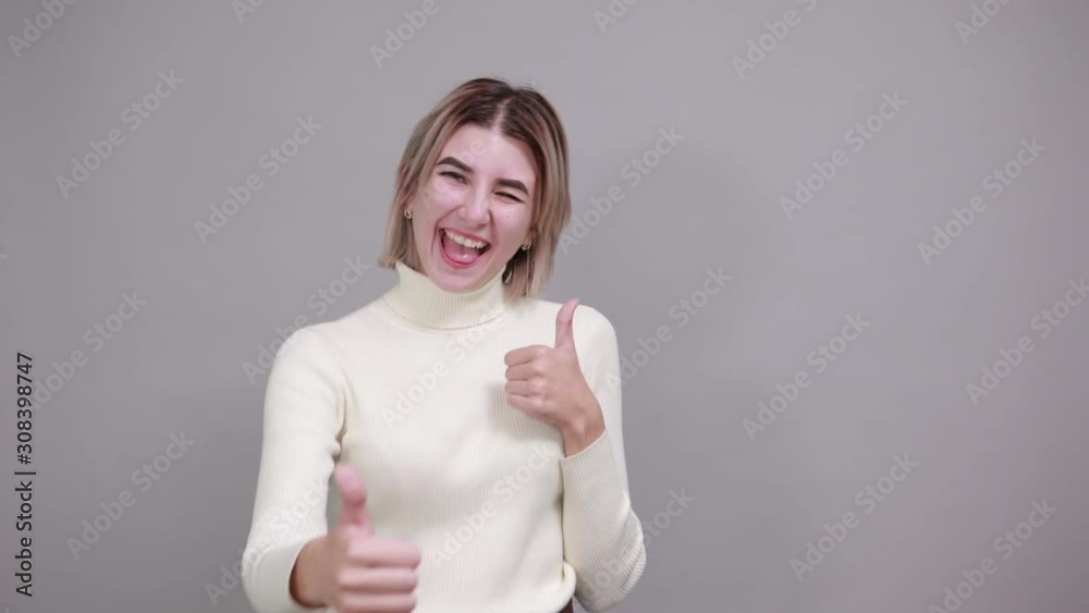 Pretty young girl over isolated gray wall wearing fashion clothes celebrating a victory in winner position, keeping fists up Pretty young girl over isolated gray wall wearing fashion clothes celebrating a victory in winner position, keeping fists up