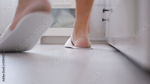 Man in the Bedroom with White Slippers in His Foots