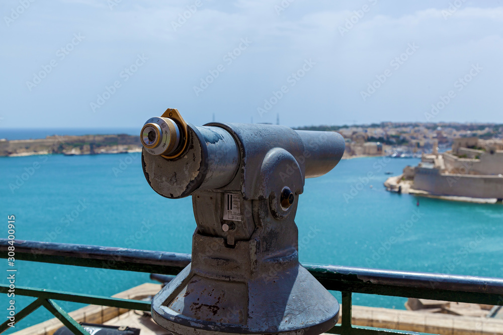 The coin-operated monocular points out on a coastal city