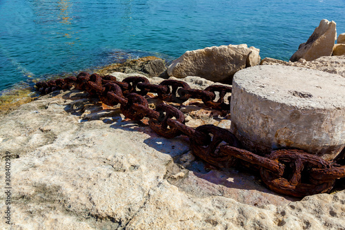 A metal chain attached to the bollard at port