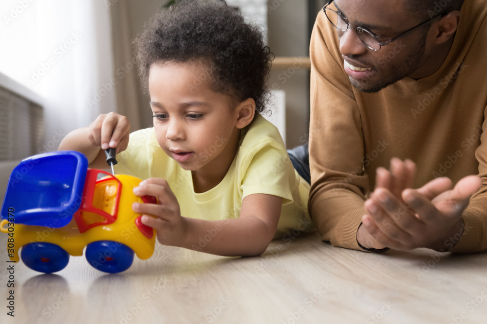 Smart little kid fix toy car playing with dad Smart little kid fix toy car playing with dad