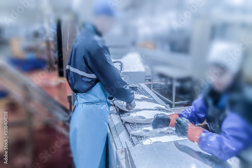 Blur, bokeh, background, abstract, image for background. Cutting the salmon on the production line in the fish processing plant