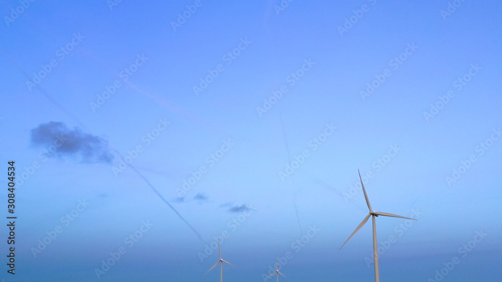Wind turbine from aerial view - Sustainable development, environment friendly, renewable energy concept. Aerial View Of Wind Turbines In Blue Sky. Wind turbine from aerial view - Sustainable development, environment friendly, renewable energy concept. Aerial View Of Wind Turbines In Blue Sky.