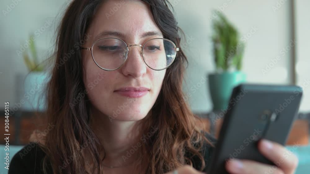 Beautiful woman, is connected to friends and family chats and texts on smartphone using messaging application, scrolls through feed on his cellphone. Beautiful woman, is connected to friends and family chats and texts on smartphone using messaging application, scrolls through feed on his cellphone.