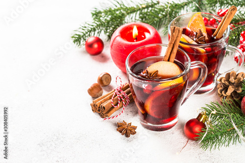 Mulled wine with christmas decorations on white. © nadianb
