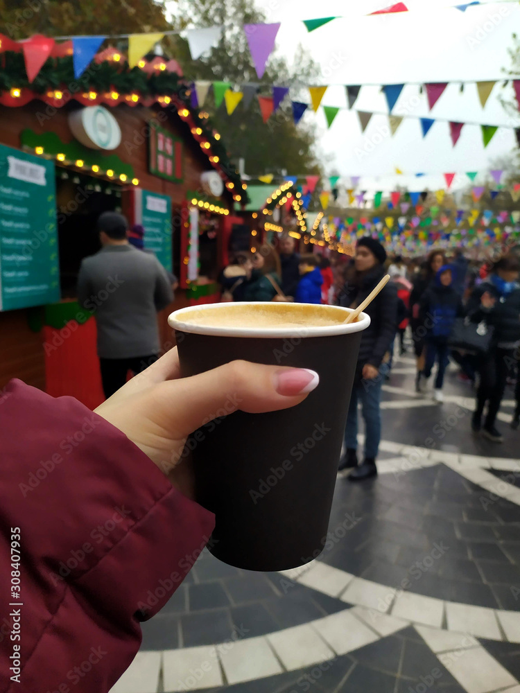 Girl holding coffee at New Year's Fair