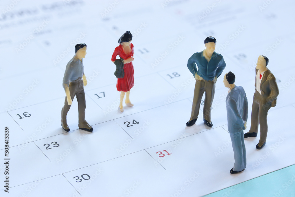miniature mannequin people, Businessman standing on the calendar to set the date for the meeting . business meetings concept.. miniature mannequin people, Businessman standing on the calendar to set the date for the meeting . business meetings concept..