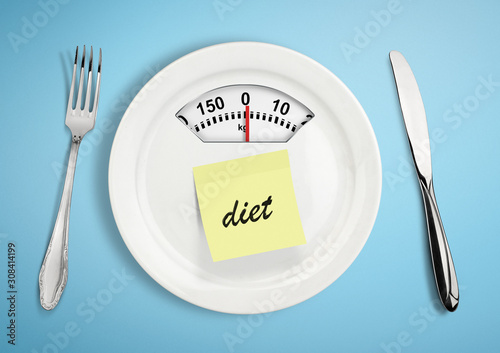 Diet and weight loss concept. Plate with scale weighing-machine