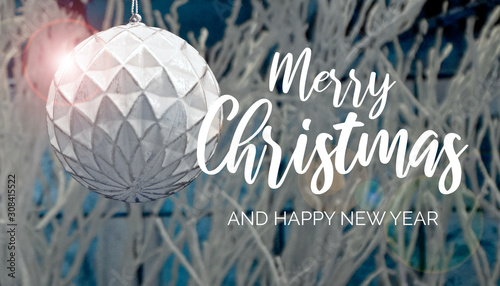Christmas greeting card with white decoration ball. Merry Christmas and Happy New Year sign. Festive white background. White Christmas greeting card. White Christmas ball on a shining background