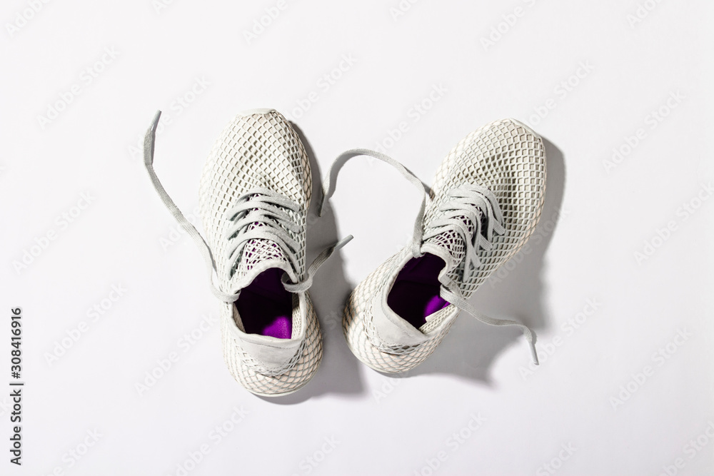 Sneakers on a white background under the morning sun. The concept of  running, fitness, cross fit. Morning running. Natural light. Flat lay, top  view Stock Photo | Adobe Stock
