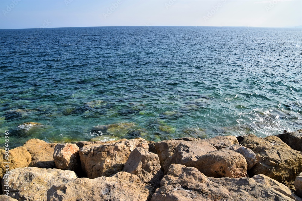 Obraz premium Blue sea, sky horizon and rocky coast summer scenery